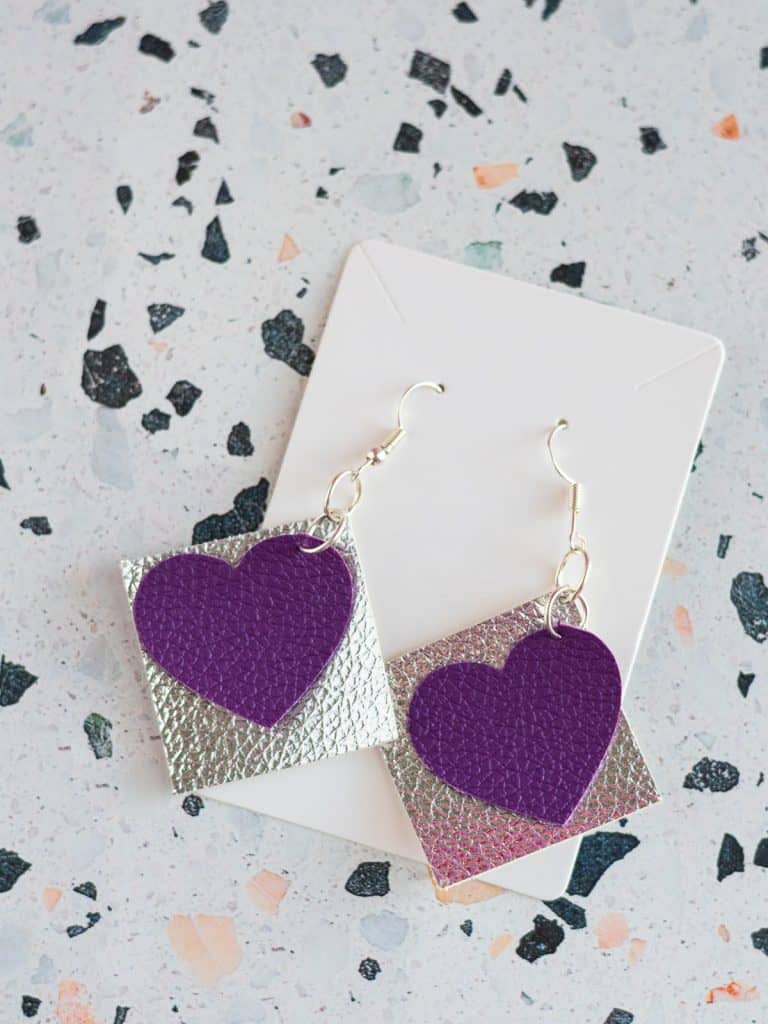 Purple faux leather heart earrings with a silver square behind them