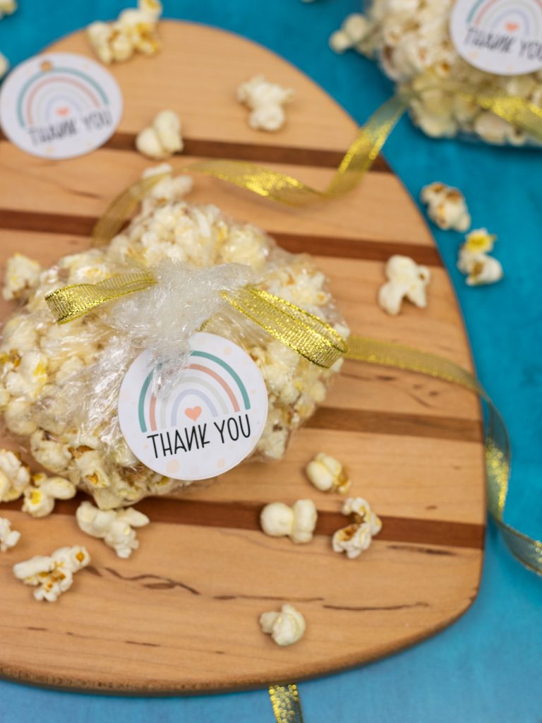 gender neutral baby shower gift tags tied to bags of fresh popcorn