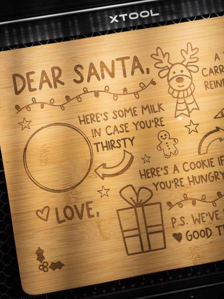 Up close image of the Cookies for Santa laser cut tray after the laser is done engraving. Because of the wood I used you can see a variation in color where it was engraved.